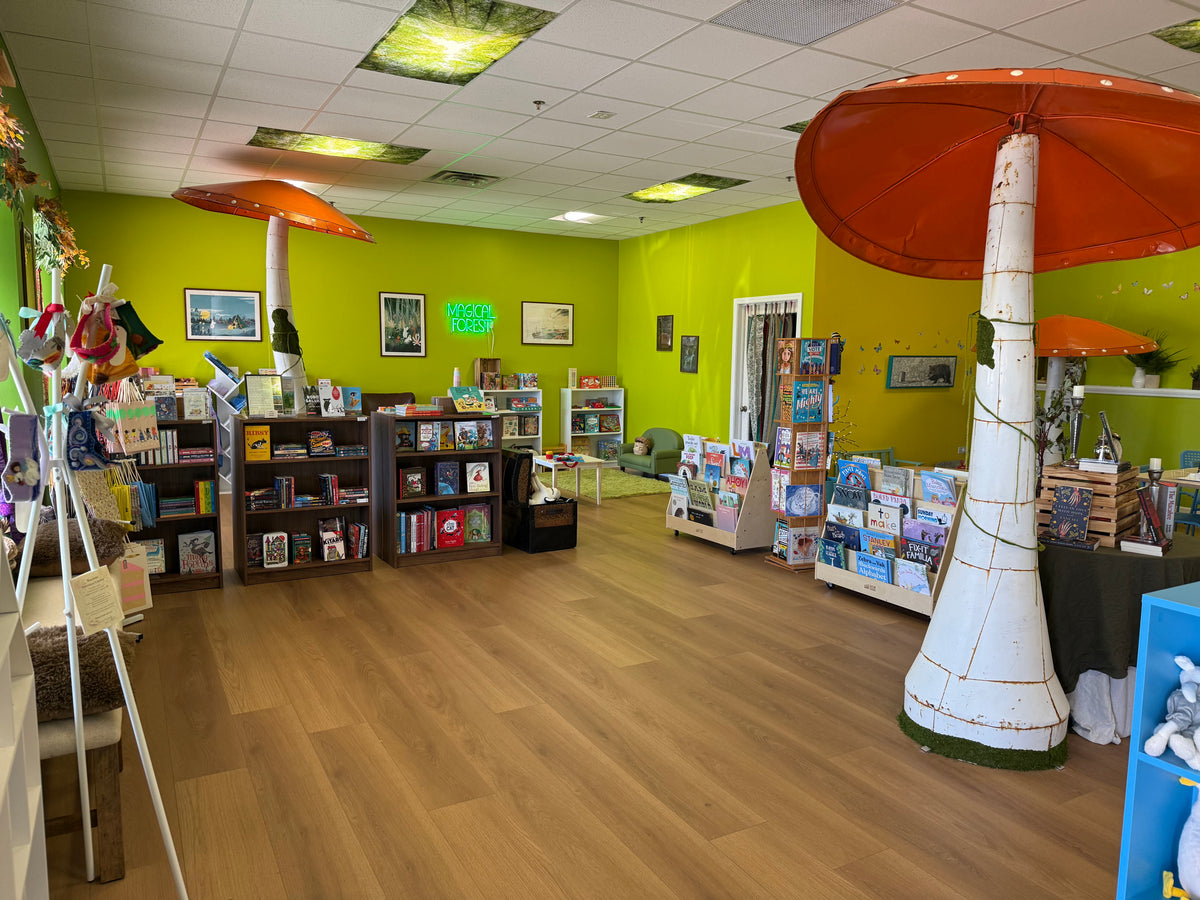 Inside Magical Forest Bookstore, with shelves of books and tall metal mushroom sculptures